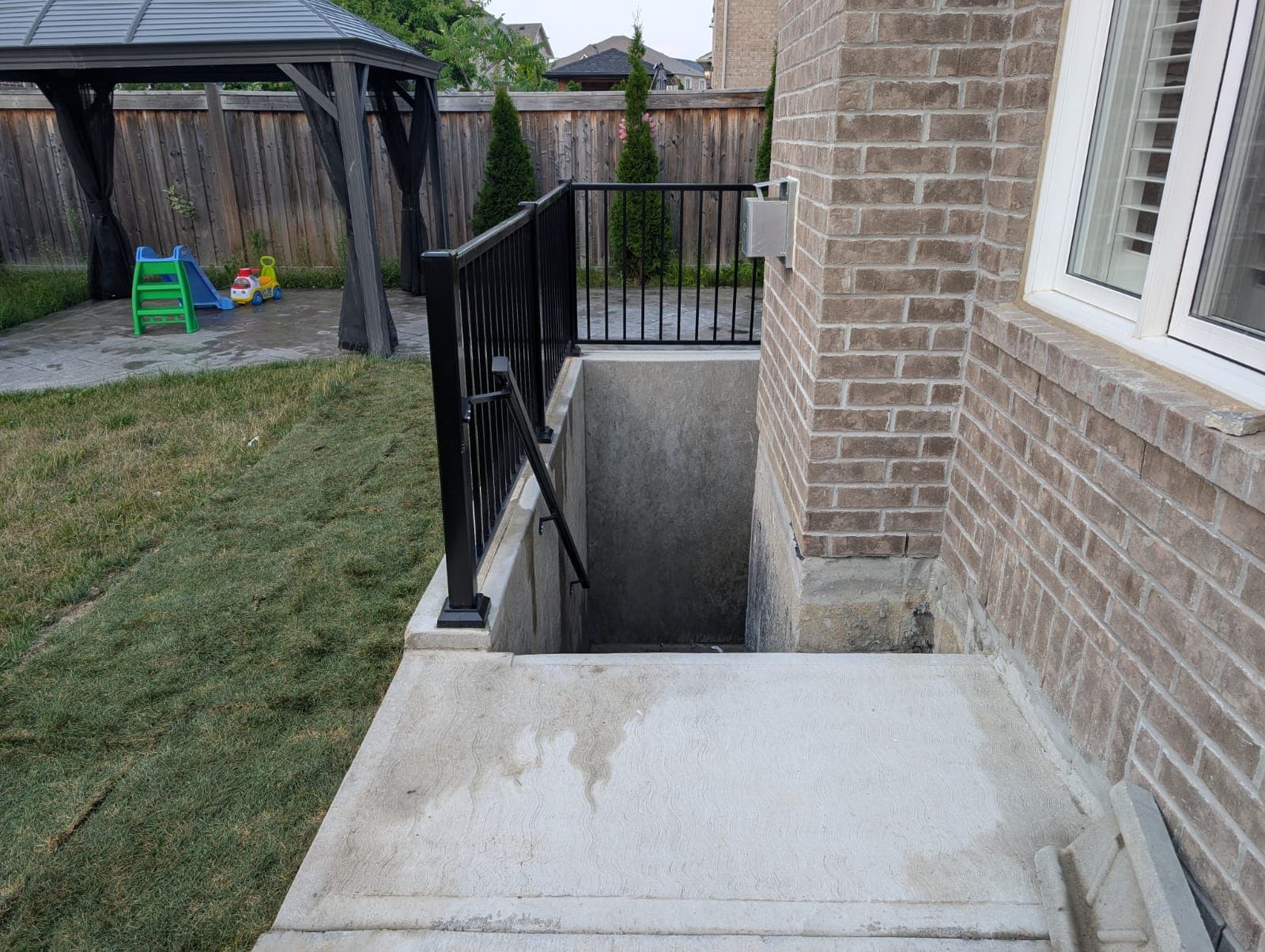 Side entryway with steps leading to a sheltered exterior door.