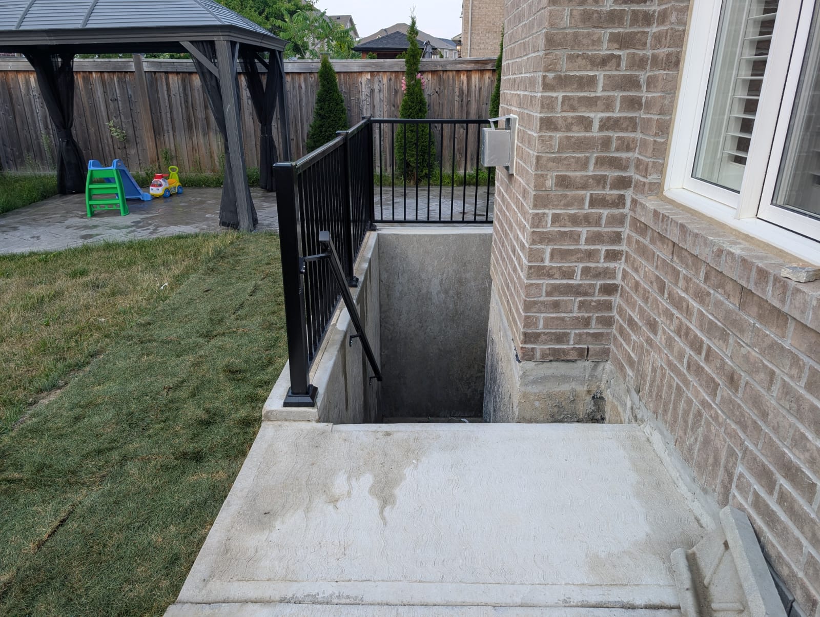Side entryway with steps leading to a sheltered exterior door.